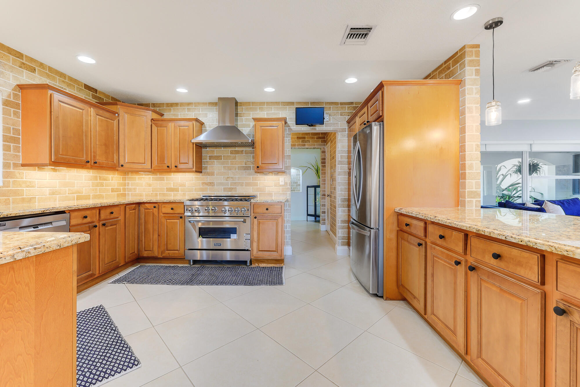 2560 Southeast 7th Drive Pompano Beach, FL 33062 - Photo 20 of 74 a kitchen with stainless steel appliances kitchen island granite countertop a refrigerator and a stove top oven