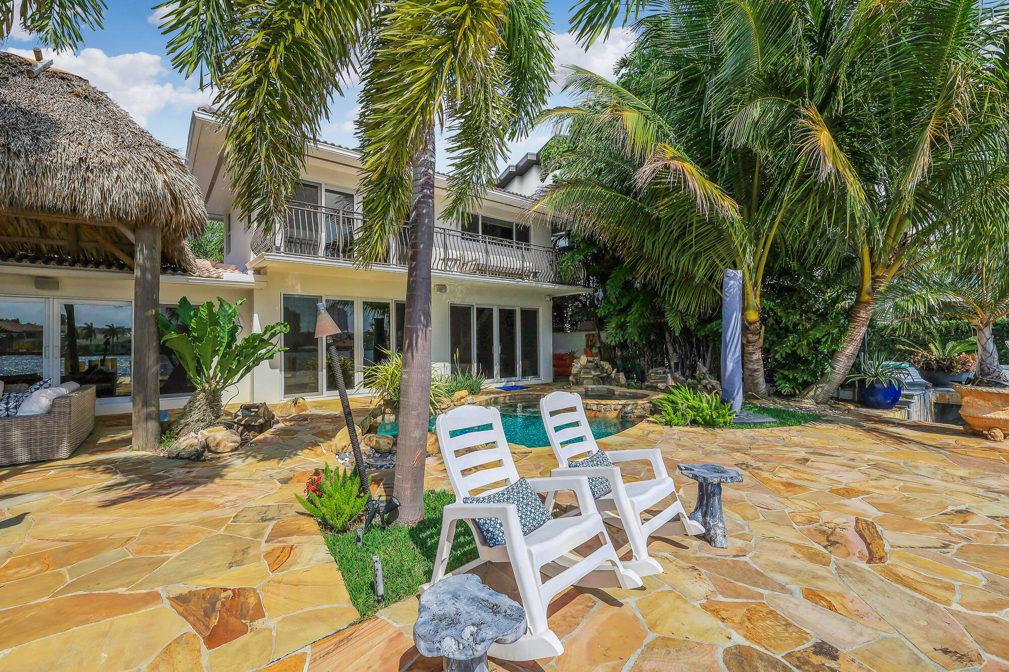 2560 Southeast 7th Drive Pompano Beach, FL 33062 - Photo 52 of 74 a view of a patio with table and chairs potted plants and palm trees