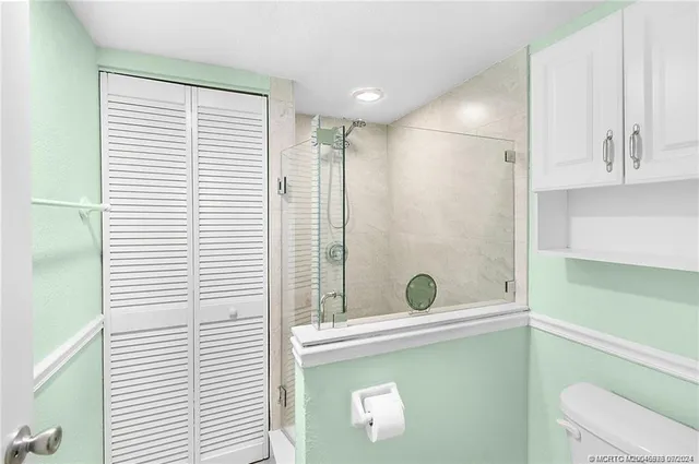 a bathroom with a granite countertop sink a toilet and shower