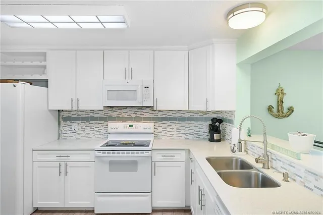 a kitchen with cabinets appliances a sink and a counter top