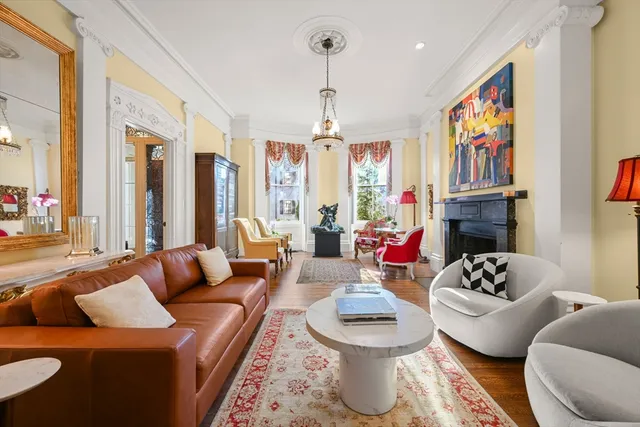 a living room with fireplace furniture and a large window
