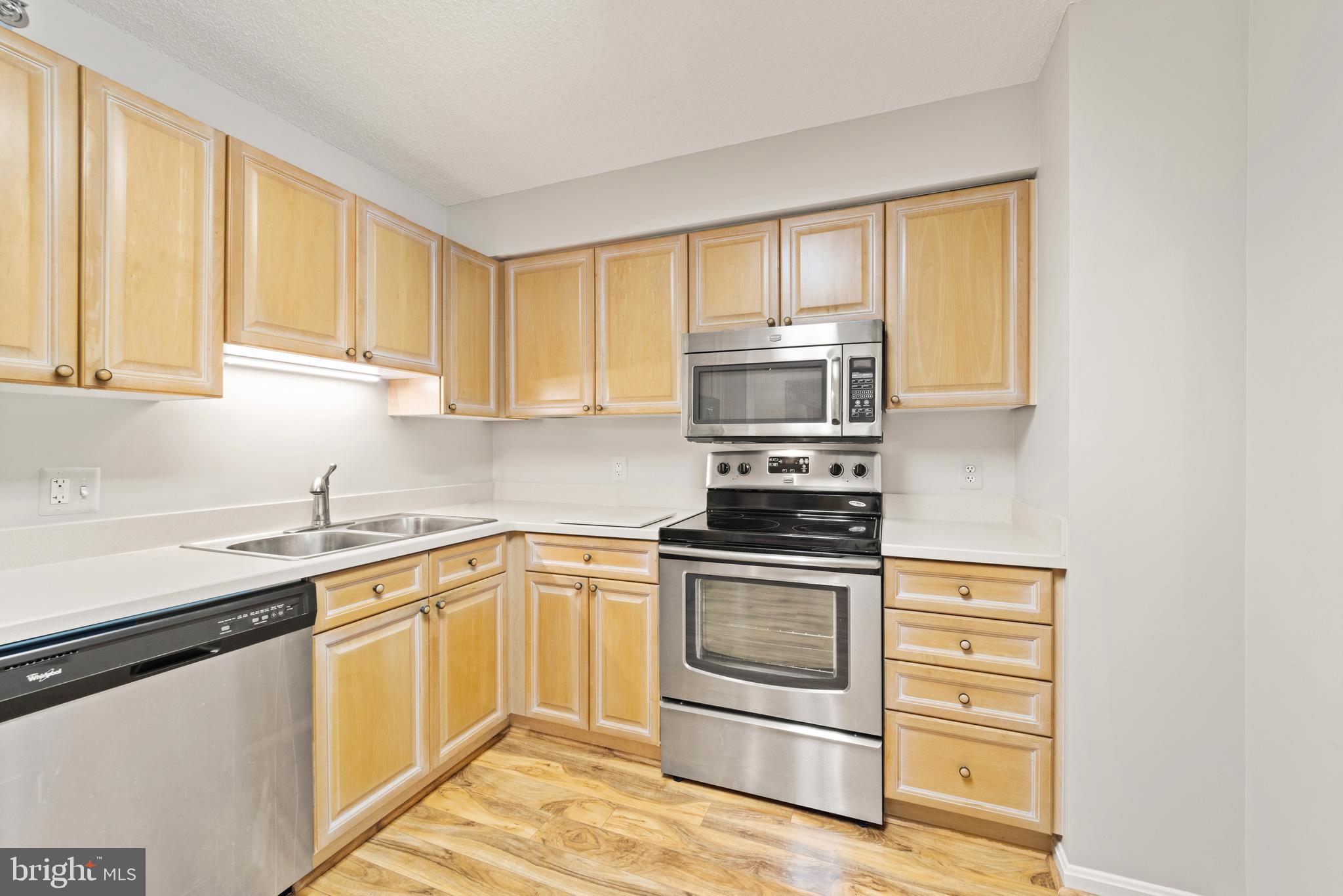 19385 Cypress Ridge Terrace, Unit 222 Leesburg, VA 20176 - Photo 1 of 17 a kitchen with a sink stove and microwave