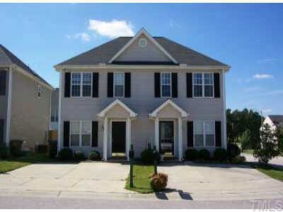 a front view of a house with yard and parking