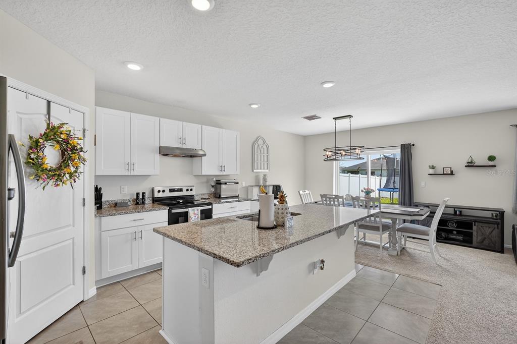 1809 Myrtlebrooke Drive Edgewater, FL 32141 - Photo 11 of 58 a kitchen with white cabinets and refrigerator