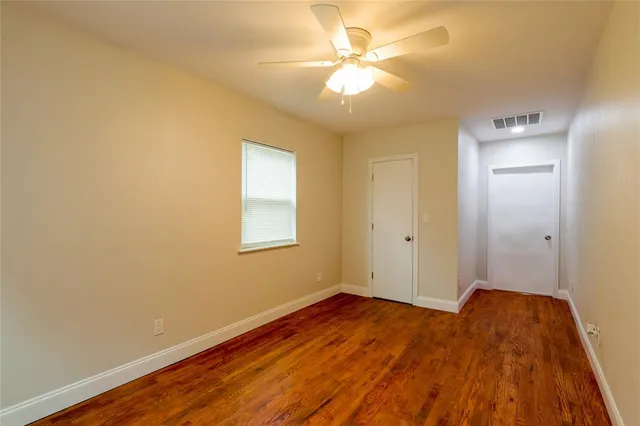 a view of a room with wooden floor and a ceiling fan