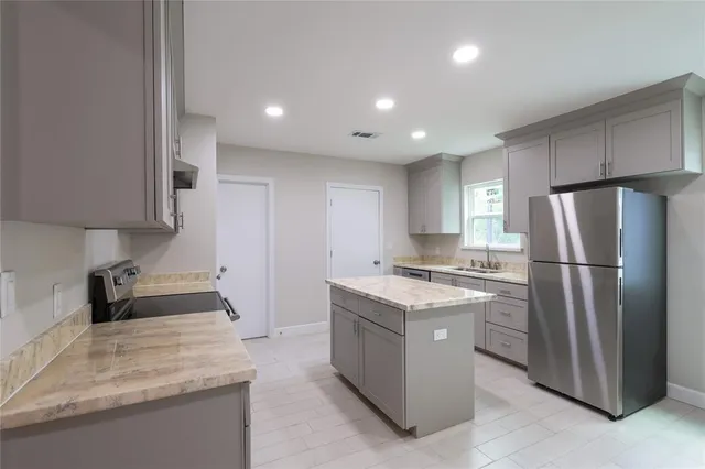 a kitchen with stainless steel appliances granite countertop refrigerator sink and cabinets