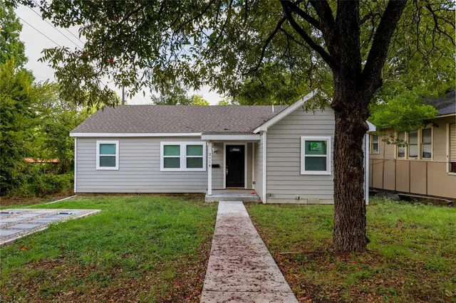 a front view of a house with yard and green space