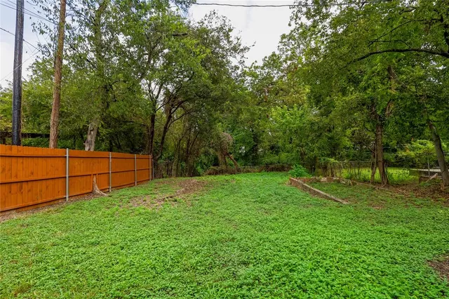 a view of backyard with wooden fence