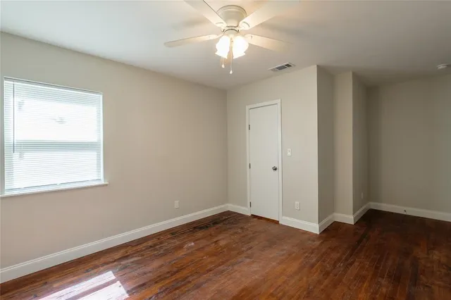 a view of a room with wooden floor and a ceiling fan