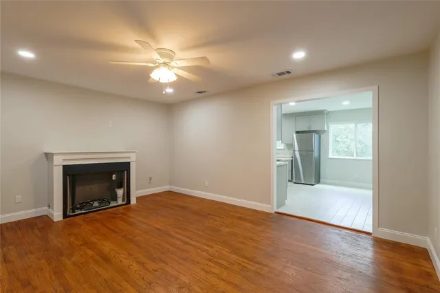 an empty room with fan and a fireplace