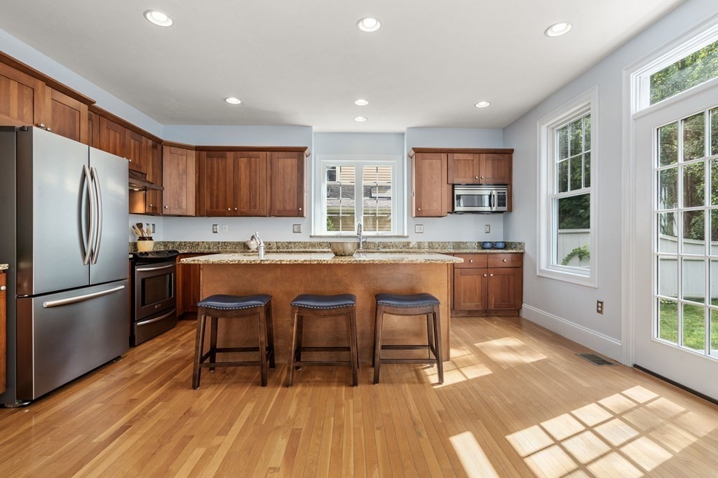 8 Maple Leaf Drive Boston, MA 02136 - Photo 6 of 29 a kitchen with stainless steel appliances granite countertop a stove a refrigerator a sink a dining table and chairs with wooden floor