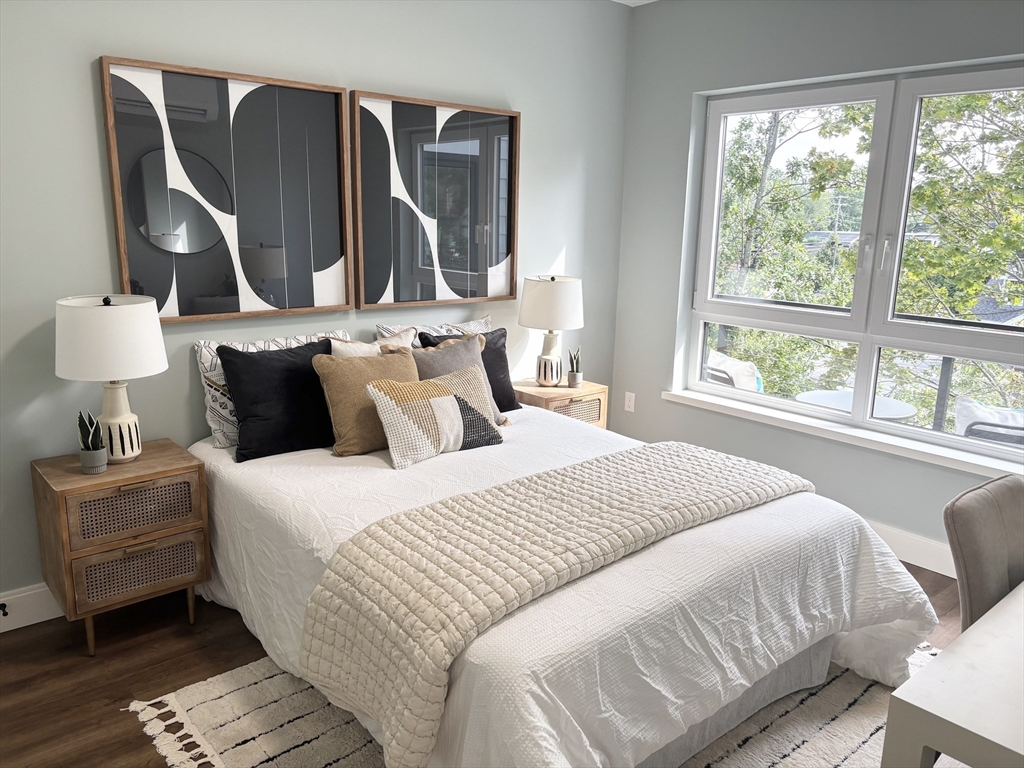 1391 Main Street, Unit 205 Walpole, MA 02081 - Photo 15 of 33 a bedroom with a bed and wooden floor