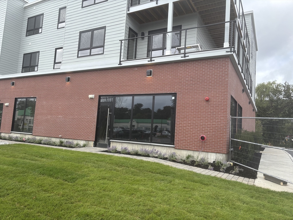 1391 Main Street, Unit 205 Walpole, MA 02081 - Photo 5 of 33 front view of a house with a yard
