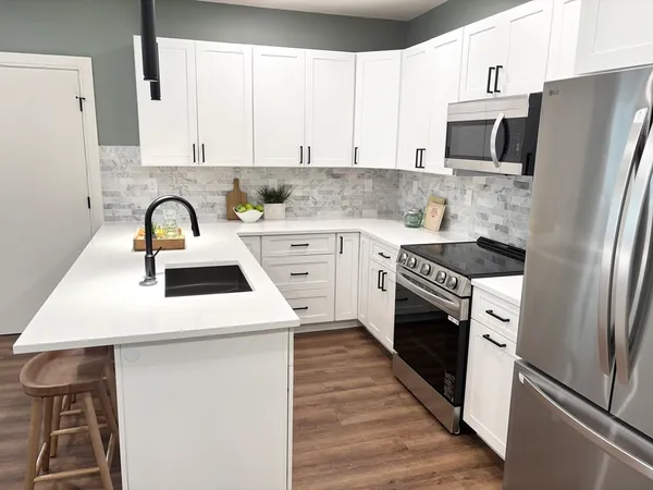 a kitchen with stainless steel appliances a stove microwave and sink