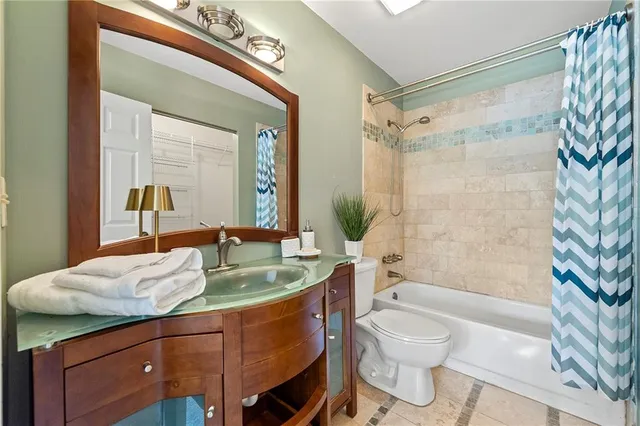 a bathroom with a granite countertop sink toilet a mirror and shower