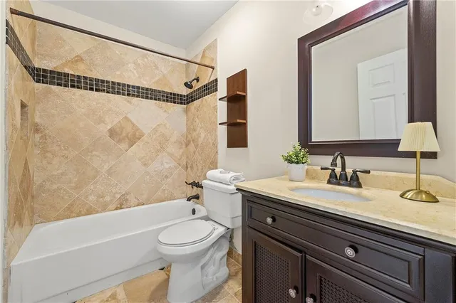 a bathroom with a granite countertop sink mirror vanity and toilet