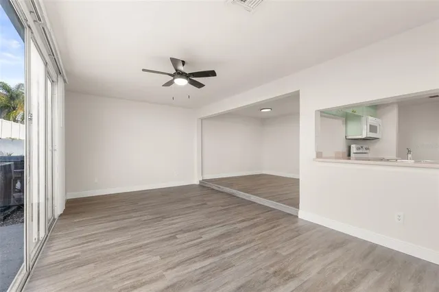 a view of a kitchen with wooden floor and a ceiling fan