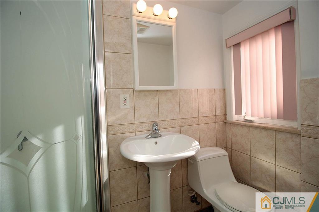 54 Starlight Drive Colonia, NJ 07067 - Photo 20 of 25 a bathroom with a sink a toilet and mirror