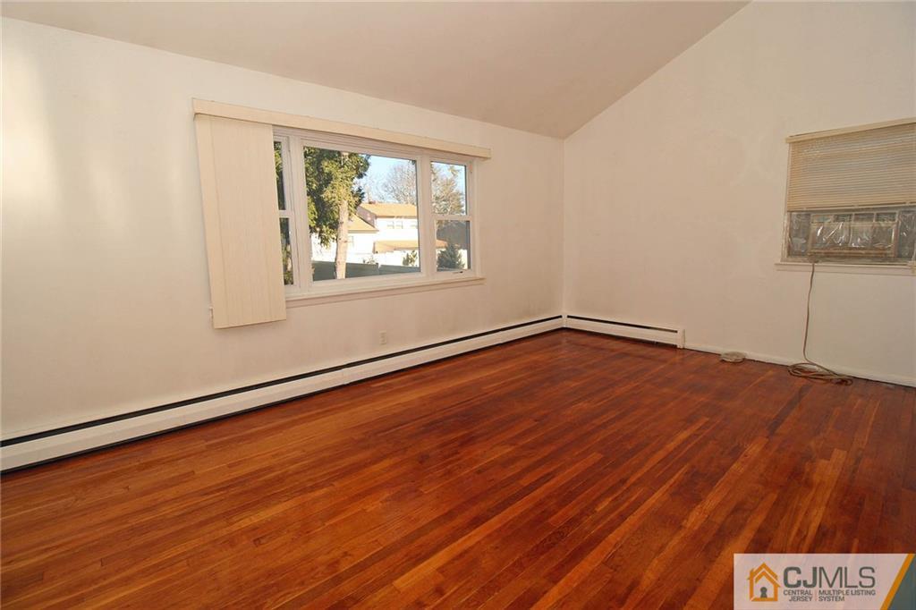 54 Starlight Drive Colonia, NJ 07067 - Photo 7 of 25 an empty room with wooden floor and windows