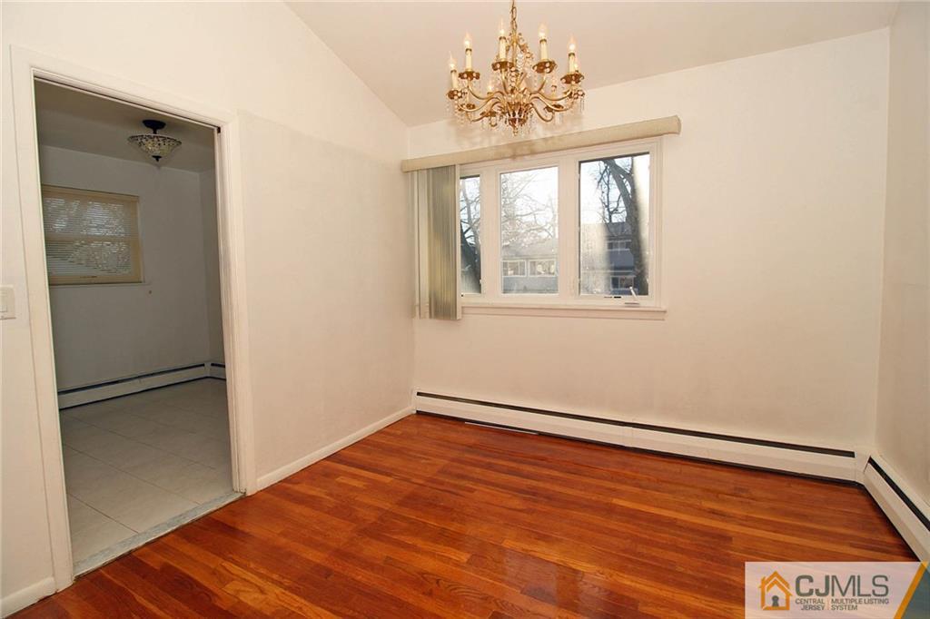 54 Starlight Drive Colonia, NJ 07067 - Photo 9 of 25 an empty room with wooden floor cabinet and windows