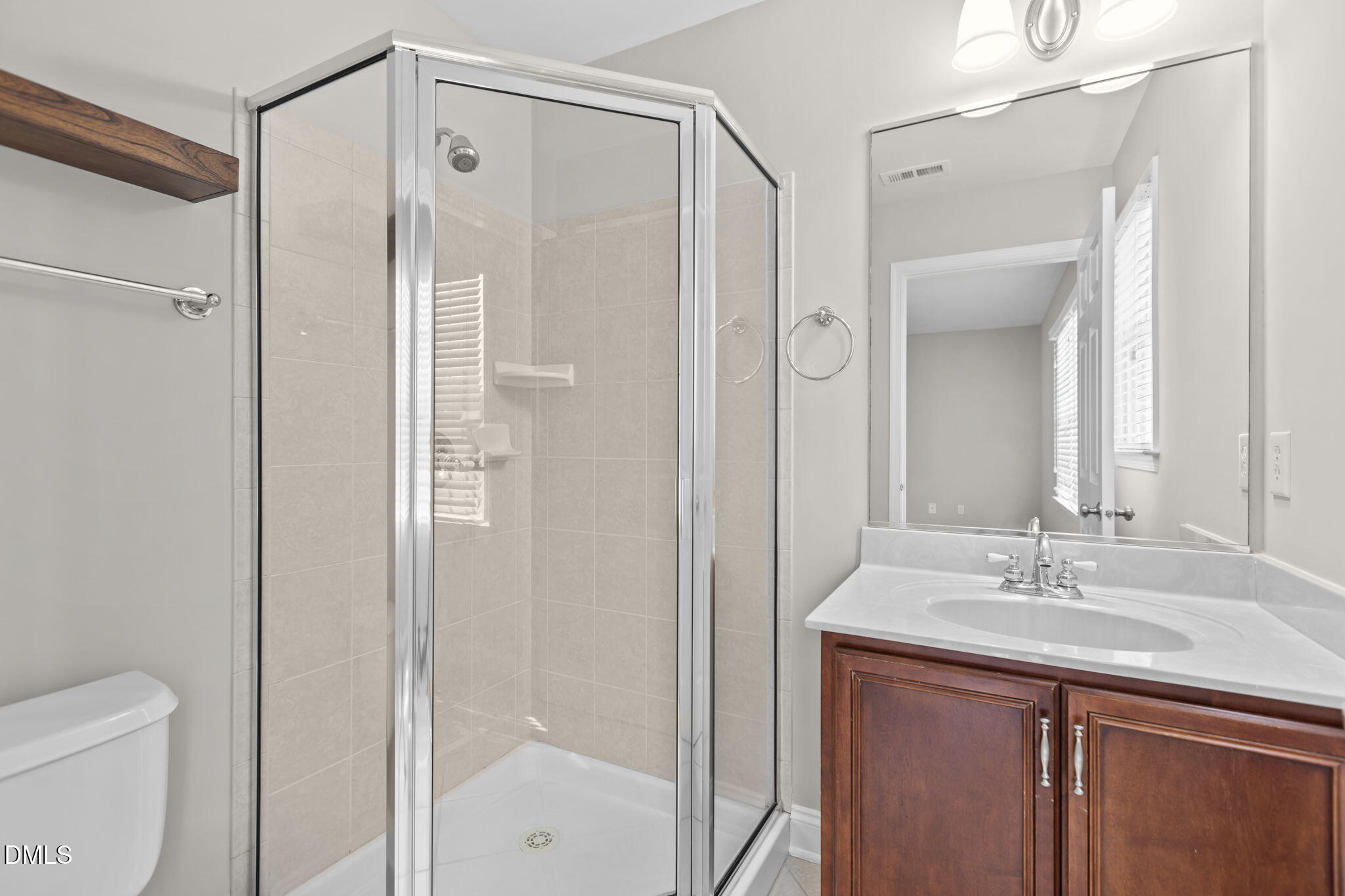 11552 Auldbury Way Raleigh, NC 27617 - Photo 33 of 62 a bathroom with a shower sink vanity and mirror