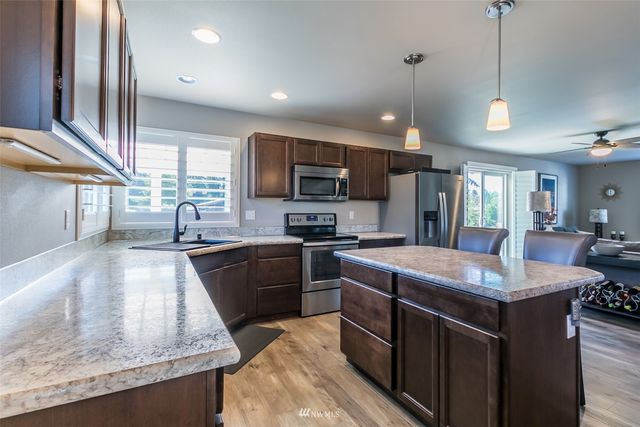 a kitchen with kitchen island granite countertop a sink stove and refrigerator