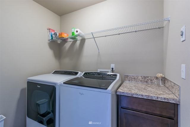 a utility room with granite countertop cabinets and sink
