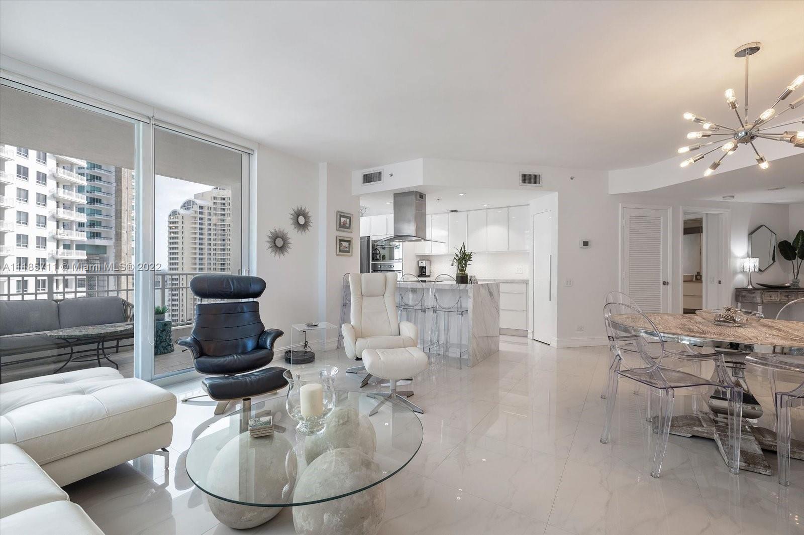 701 Brickell Key Boulevard, Unit 1704 Miami, FL 33131 - Photo 11 of 31 a living room with furniture and a chandelier