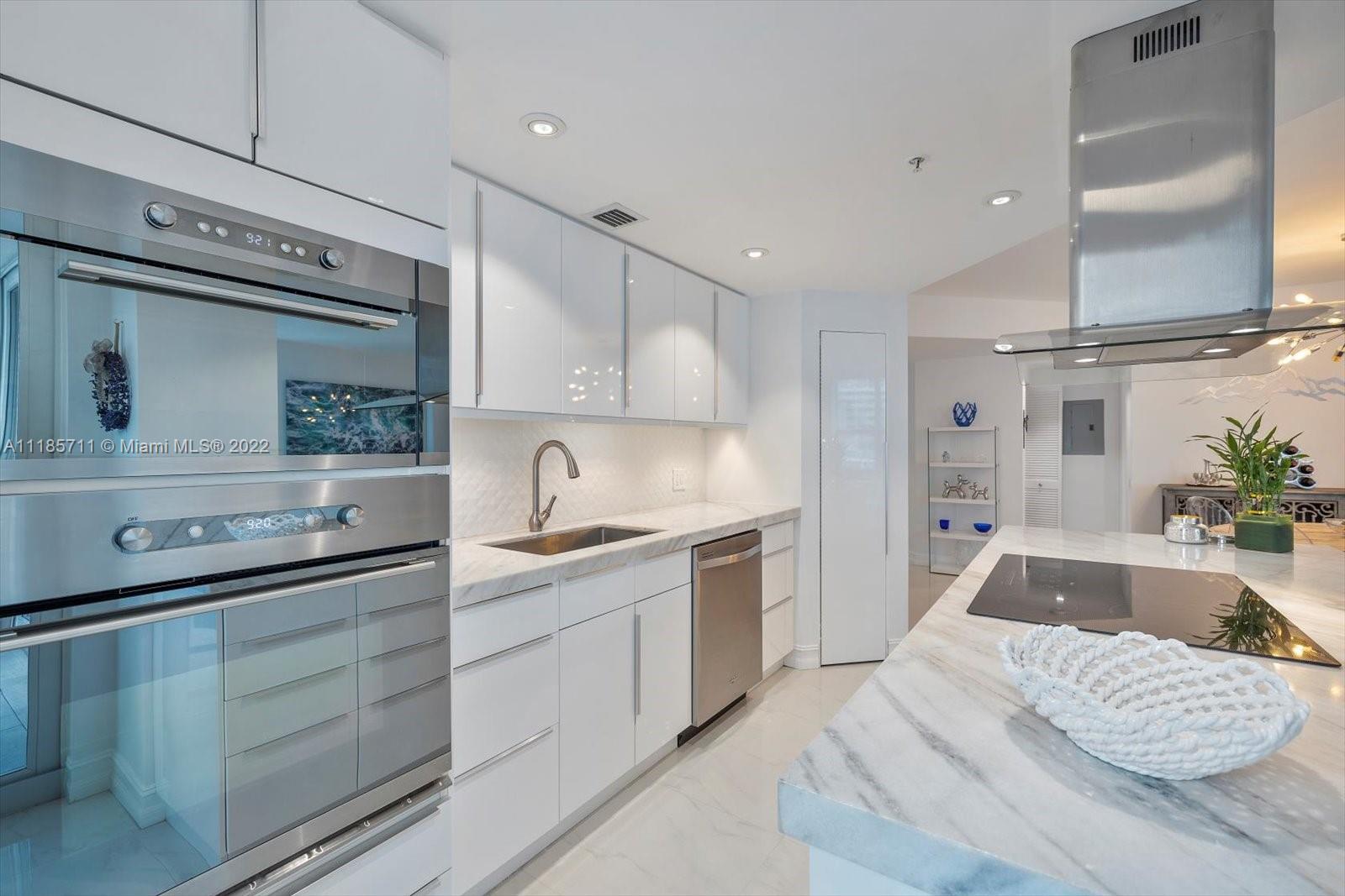 701 Brickell Key Boulevard, Unit 1704 Miami, FL 33131 - Photo 8 of 31 a kitchen with a sink stove and cabinets