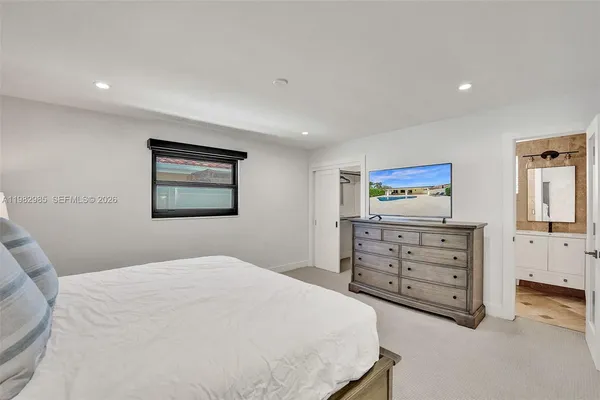 a bedroom with a bed and a flat screen tv