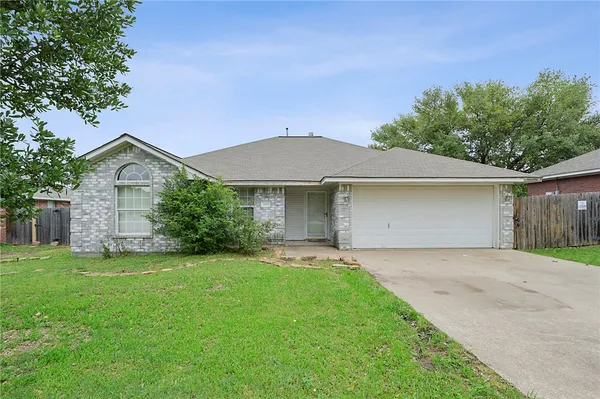 a front view of a house with a garden and yard