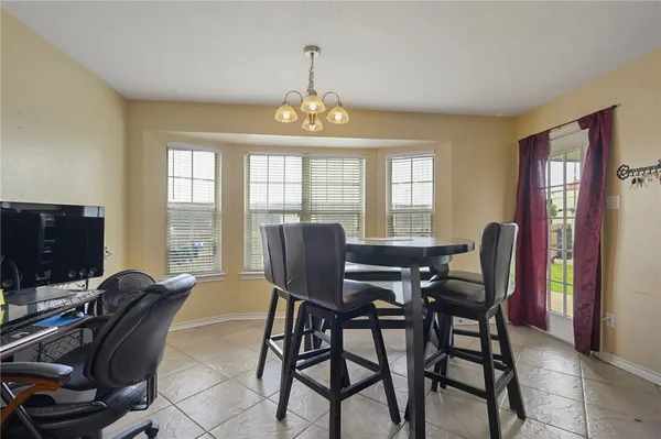 a view of a dining room with furniture a chandelier and window