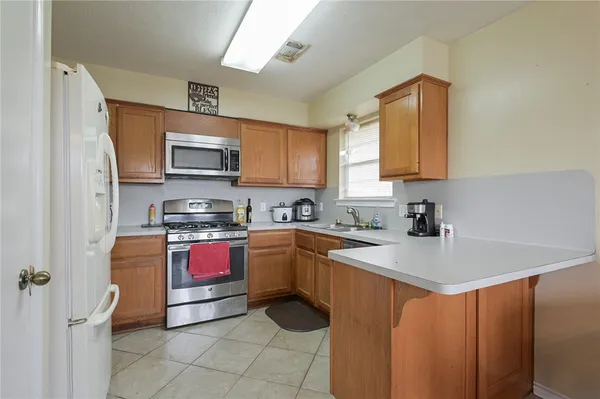 a kitchen with stainless steel appliances granite countertop a sink refrigerator and microwave