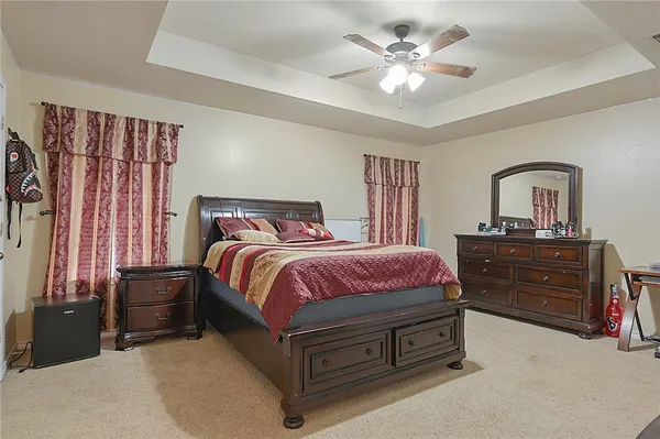 a spacious bedroom with a bed and a chandelier