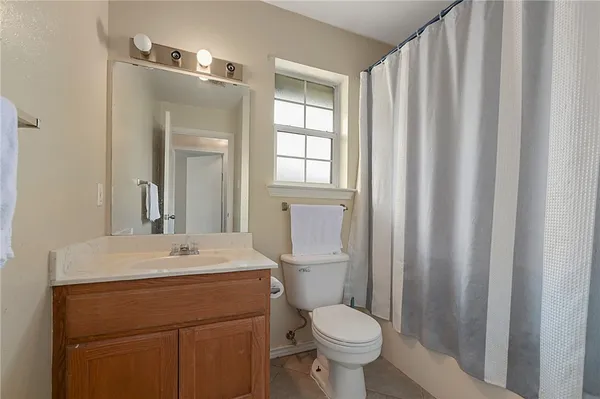 a bathroom with a sink toilet and window