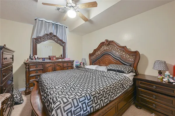 a bedroom with a bed and dresser with mirror