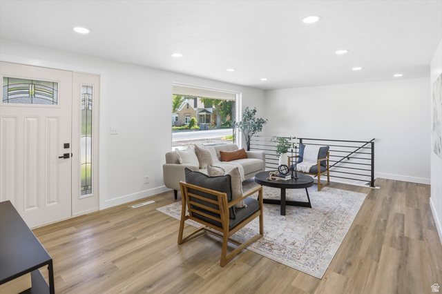 810 East Maple Street Mapleton, UT 84664 - Photo 5 of 49 Bright living area featuring wood-finish flooring, recessed lighting, a modern horizontal railing, a picture window, and a front entry door with leaded glass accents