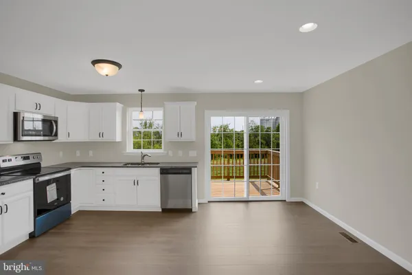 a large kitchen with granite countertop a stove top oven a sink with granite countertops and cabinets