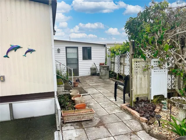 a view of house with backyard and sitting area