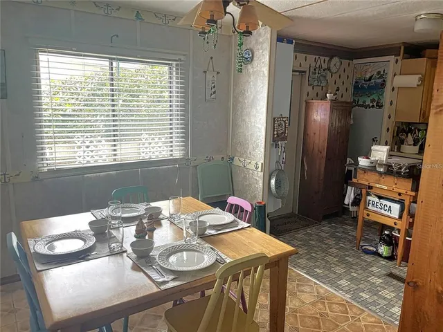 a view of a dining room with furniture a chandelier and wooden floor