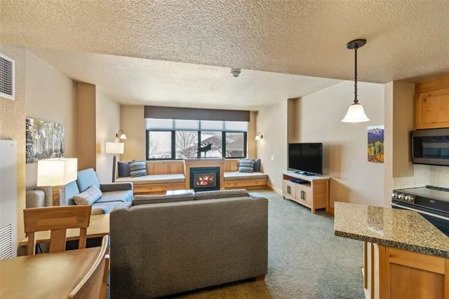 a living room with furniture a flat screen tv and a large window