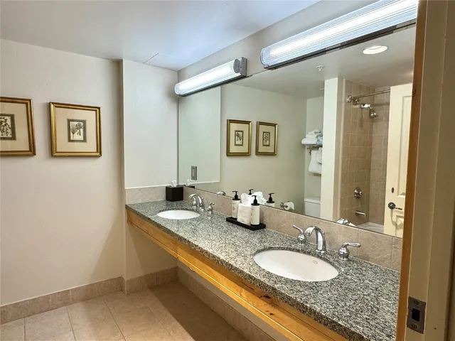 a bathroom with a granite countertop sink a mirror and vanity
