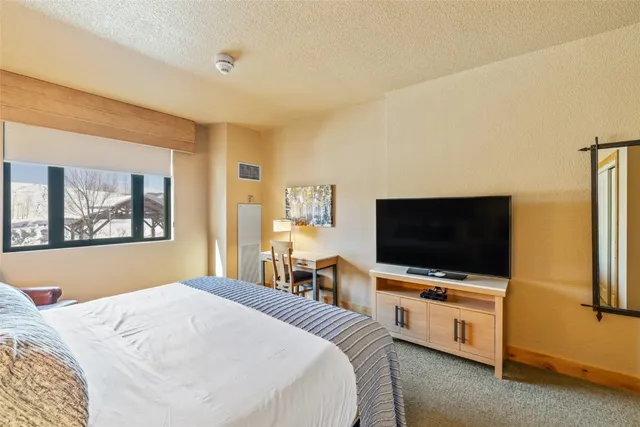 a bedroom with a flat screen tv and a bed