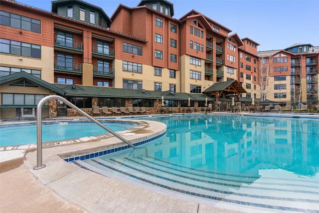 a front view of a building with swimming pool and outdoor seating