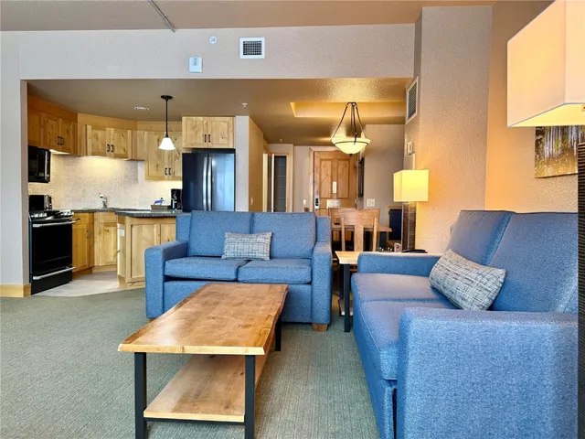 a living room with furniture and kitchen view