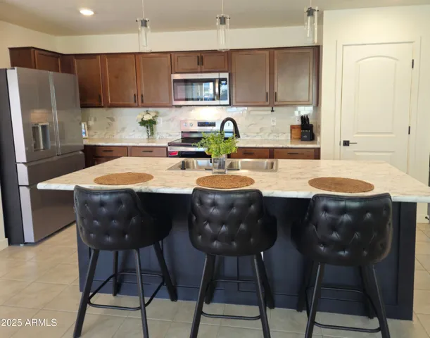 a kitchen with a table chairs stove and refrigerator