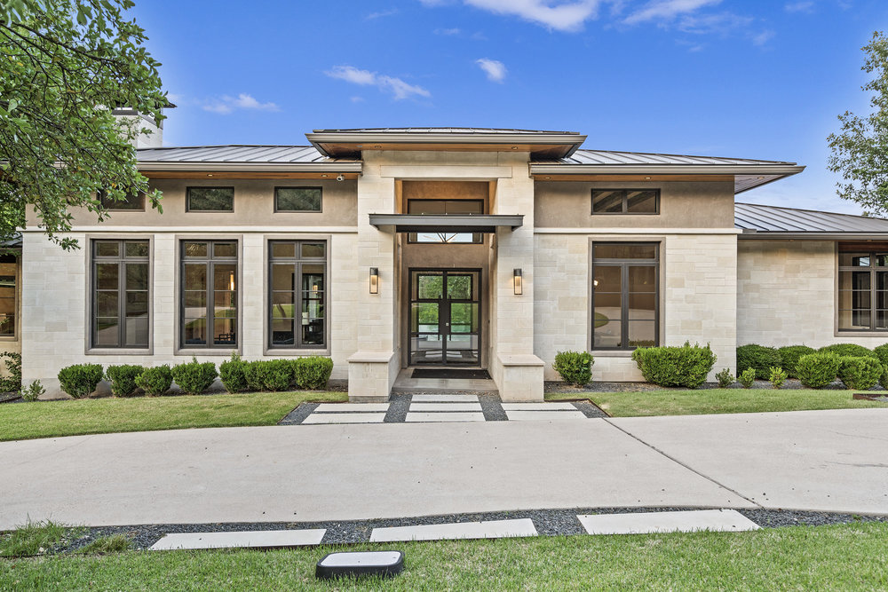 1905 Paisano Road Austin, TX 78746 - Photo 5 of 40 A contemporary exterior showcasing clean lines and a harmonious blend of stone and glass accents.