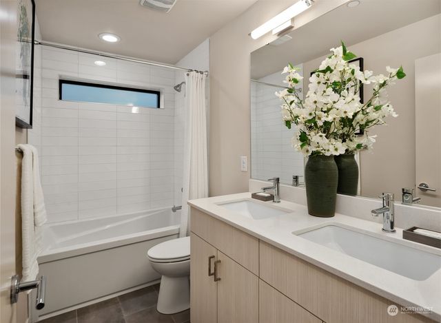 a bathroom with a double vanity sink mirror and shower