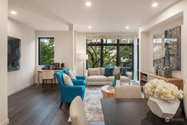 a living room with stainless steel appliances furniture and a kitchen view