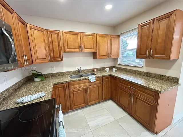a kitchen with stainless steel appliances granite countertop a refrigerator and a sink